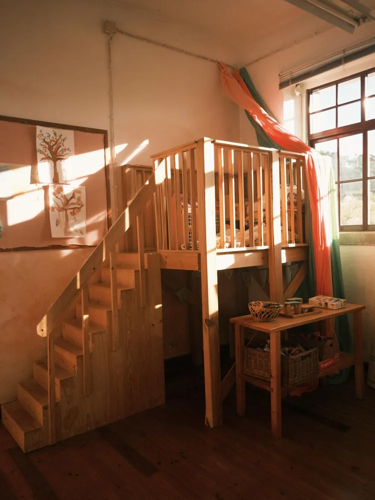 Wooden stairs leading to the raised play area inside Wildflowers