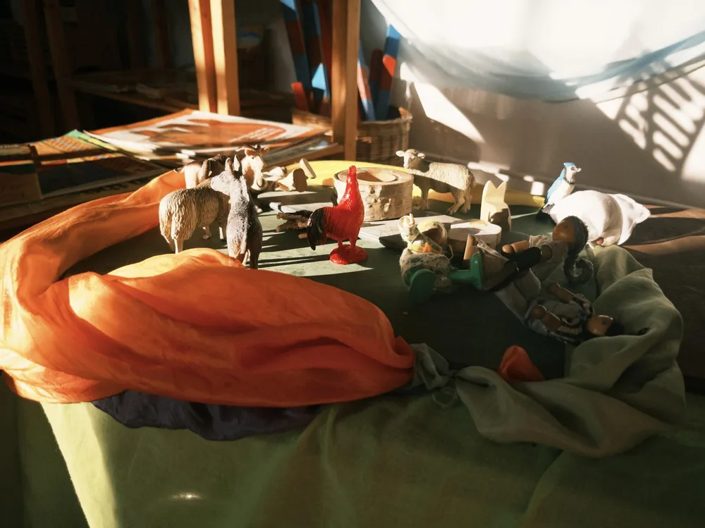 A small-world play scene made with colourful fabrics and figures