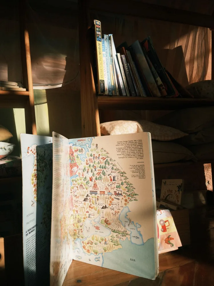 An illustrated storybook open beside the reading shelves